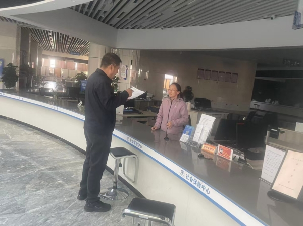 沙湾市政务服务中心社保窗口干部朱园园为群众打印工伤保险报销明细.jpg